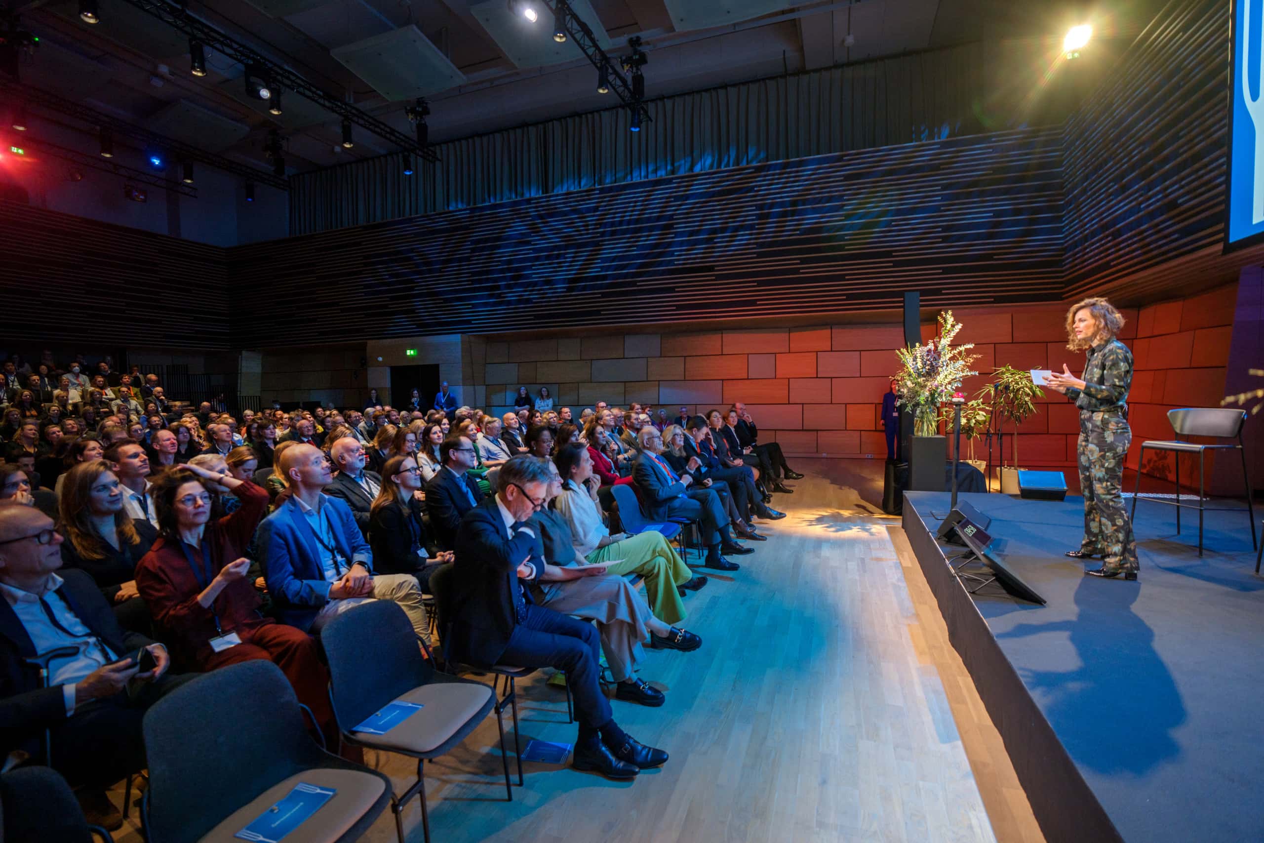 Persoon spreekt een volle zaal toe