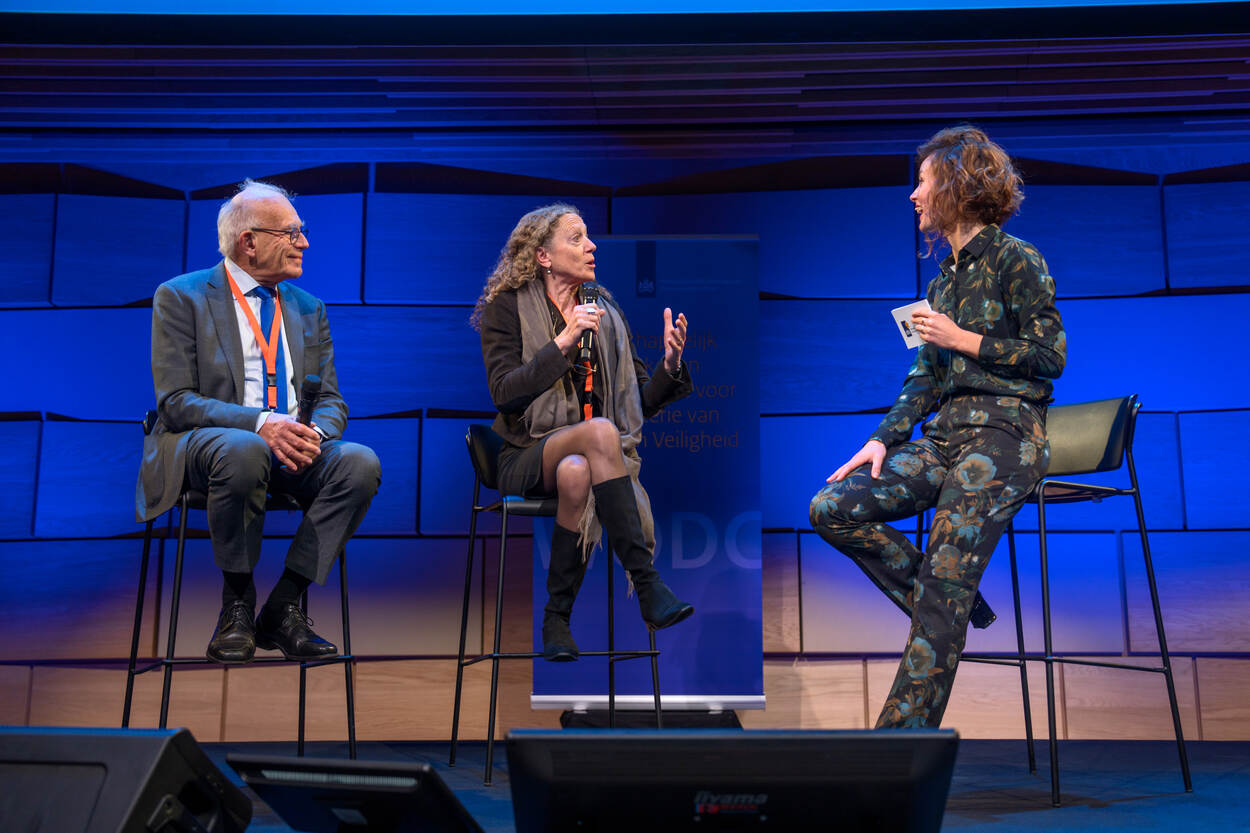 Drie mensen met elkaar in gesprek op een podium tijdens het jubileumcongres van het WODC